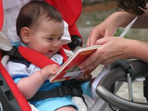 Andiamo dritti alle storie, foto di bambino in passeggino che legge un libro