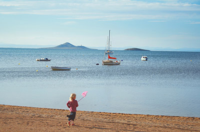 Foto di marche con barche, spiaggia e una bambina